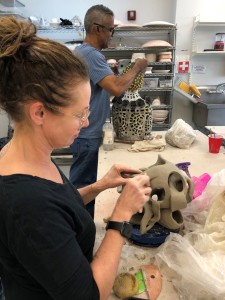 Two participants at an artist work table crafting their ceramic sculptures in a VisArts workshop.